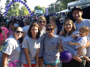 Several people with gray IMC shirts taking a picture. A crowd is in the background.