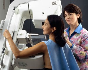 Picture of 2 women. One is getting a mammogram