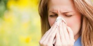 Picture of a woman sneezing with tissues
