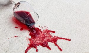 wine glass with red wine spilled on carpet