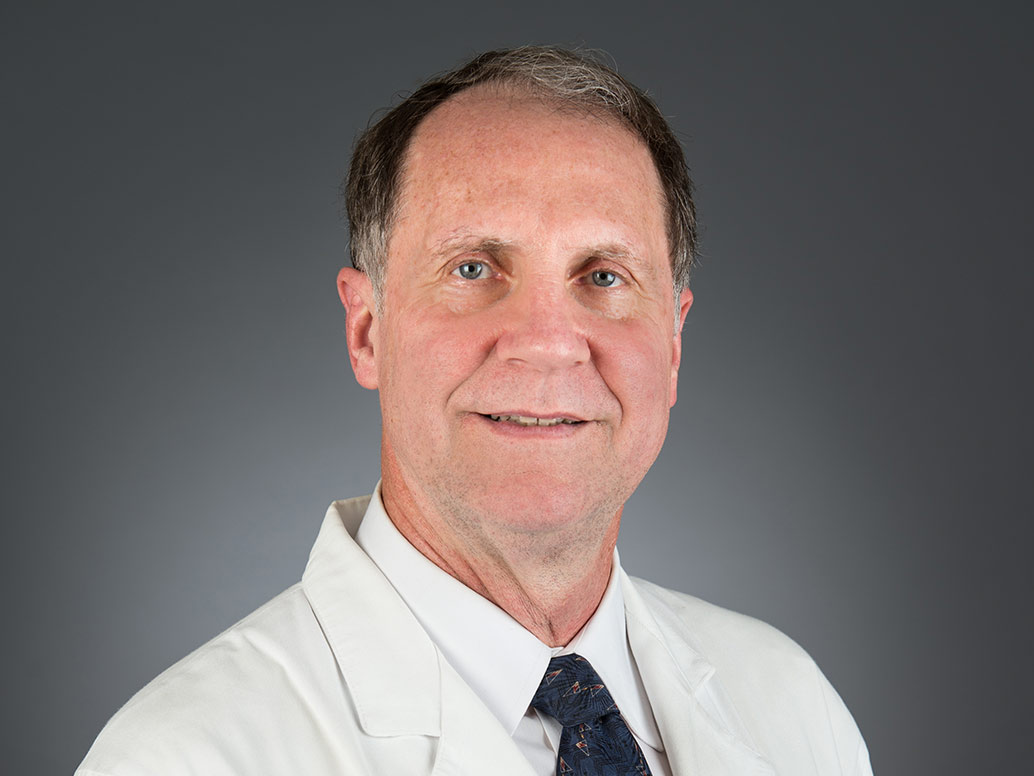 Picture of Alan R. Shain, M.D. in white lab and dark tie