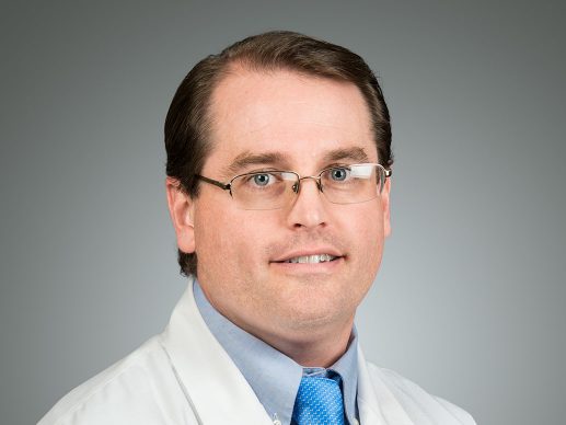 Picture of J. Gray Arnold Jr., MD in a white lab coat with a blue tie