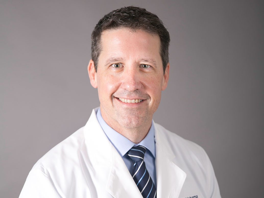 Picture of Michael K. Sanders, M.D., FASGE in a white lab coat and dark blue striped tie