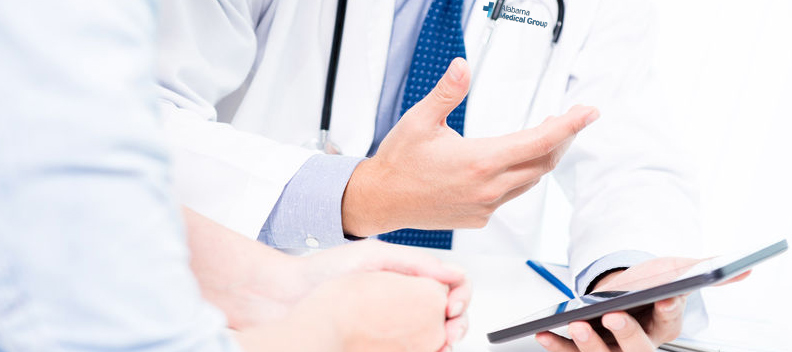 chest down shot of doctor talking to patient from an ipad