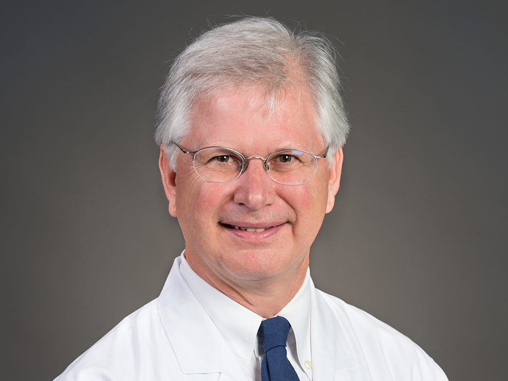 Picture of C. Adrien Bodet III, M.D. in a white lab coat and blue tie