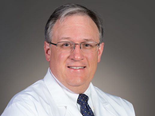 Picture of Edward A. Hyndman III, M.D. in white lab coat in dark blue tie