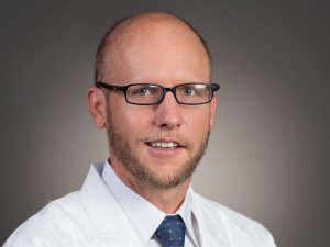 Picture of Timothy M. Iliff Jr., M.D. in white lab coat in dark blue tie