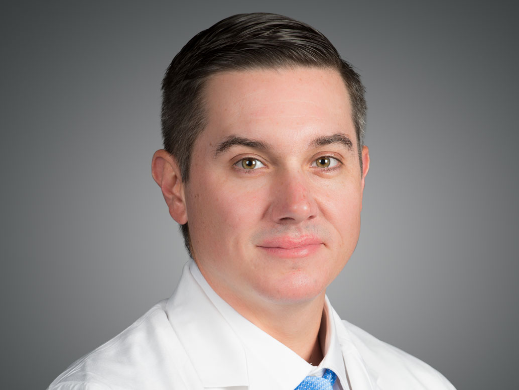 Picture of Jarrod Coggin, CRNP in a white lab coat and blue tie