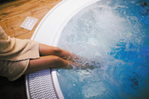 person with legs in hot tub